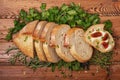 Neatly sliced Ã¢â¬â¹Ã¢â¬â¹bread with fresh herbs and a sandwich with butter and sun-dried tomatoes